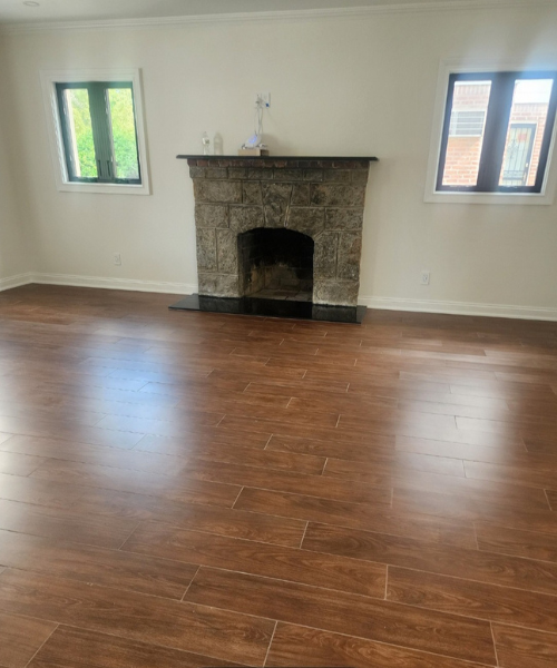 A living room with a fireplace and hard wood floors