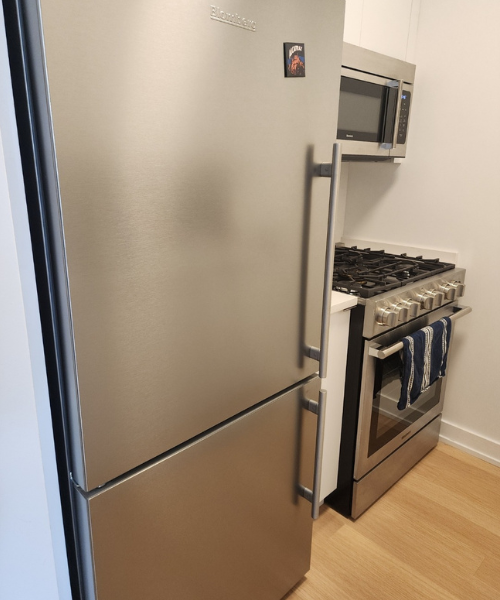 A silver refrigerator freezer sitting inside of a kitchen