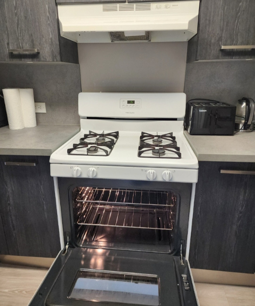 A white stove top oven sitting inside of a kitchen